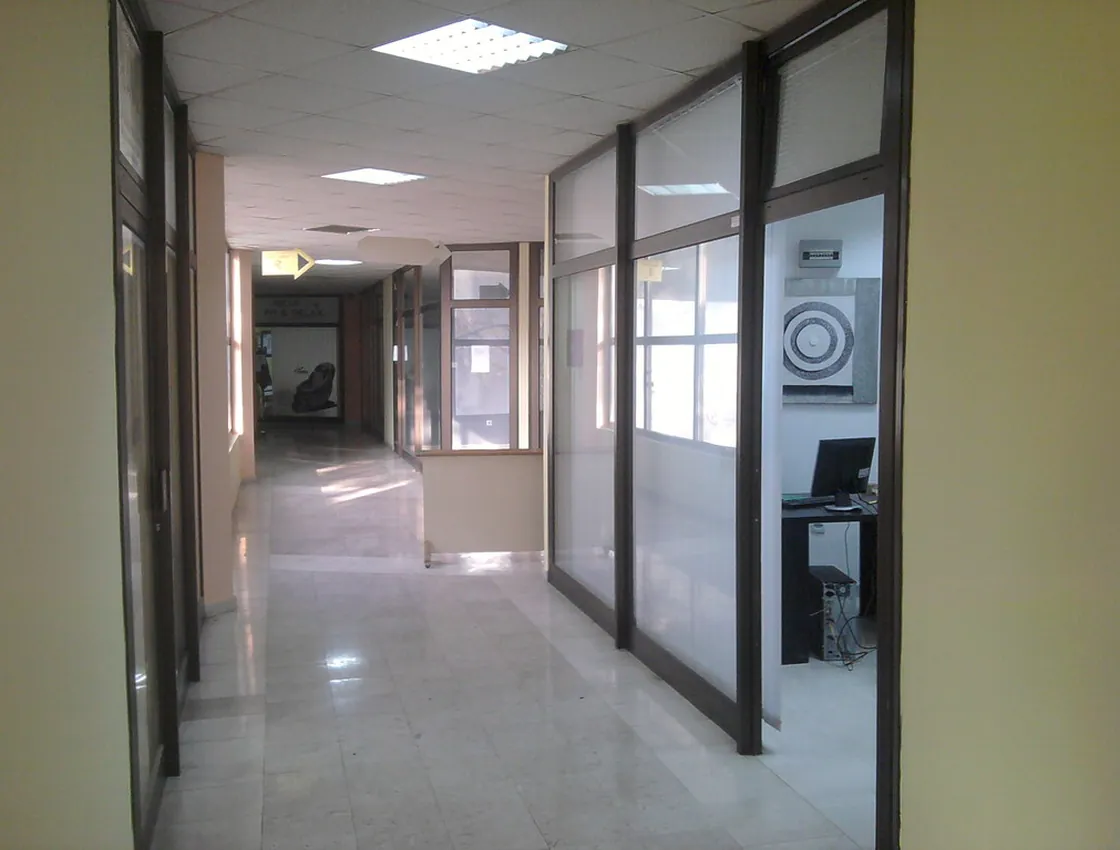 An office corridor with a glossy, freshly maintained hard floor.
